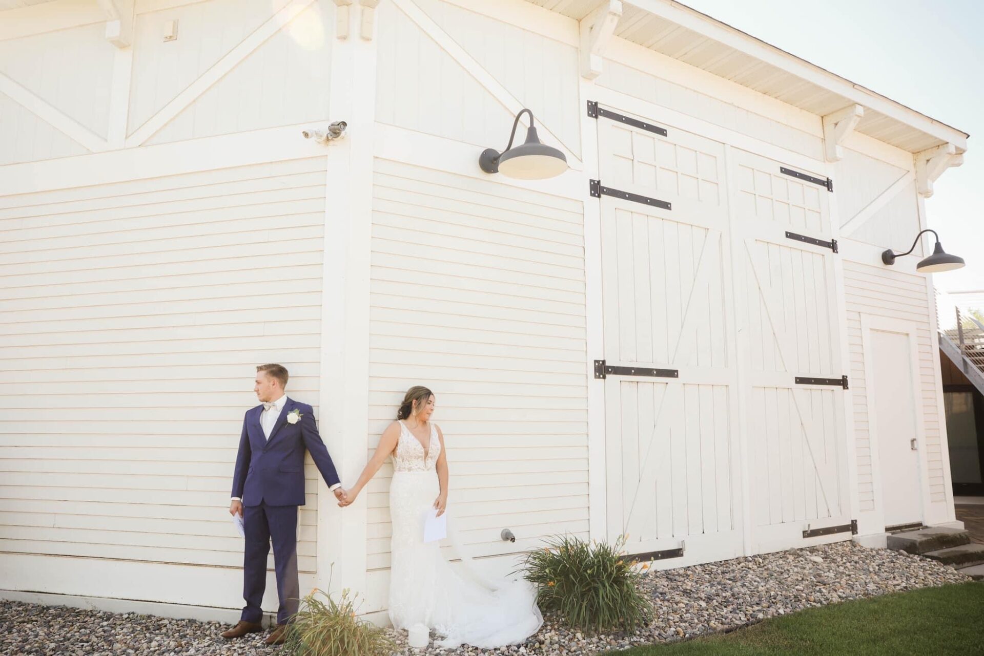 wedding couple outside white barn